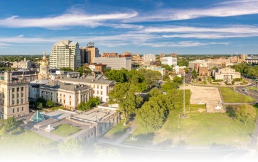 Scenic aerial view of Mercer County, NJ, showcasing historic buildings, green spaces, and a vibrant cityscape under a bright blue sky.